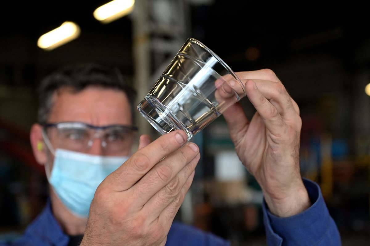 A worker controls a glass at the end of the production line at a factory of French manufacturer of glassware Duralex in La Chapelle-Saint-Mesmin
