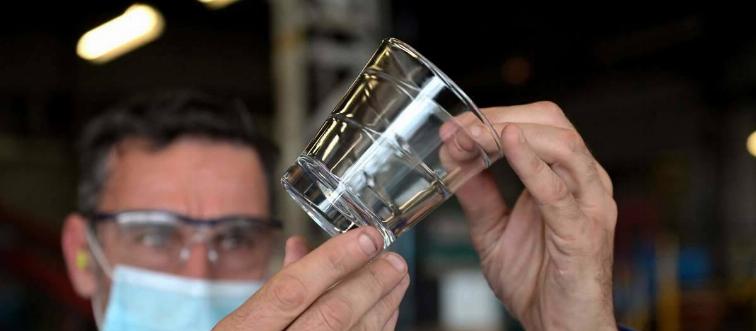 A worker controls a glass at the end of the production line at a factory of French manufacturer of glassware Duralex in La Chapelle-Saint-Mesmin