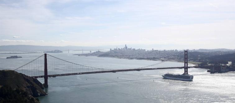 A cruise ship passes under the Golden Gate Bridge in San Francisco