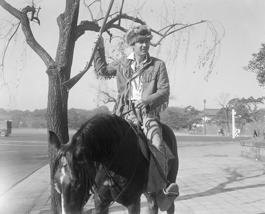 actor Fess Parker dressed as davy crockett on a horse