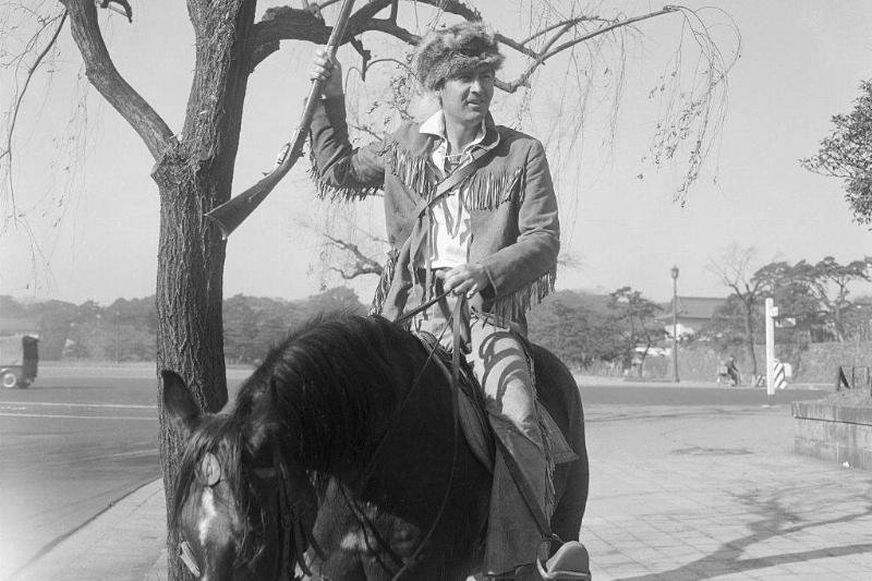 actor Fess Parker dressed as davy crockett on a horse