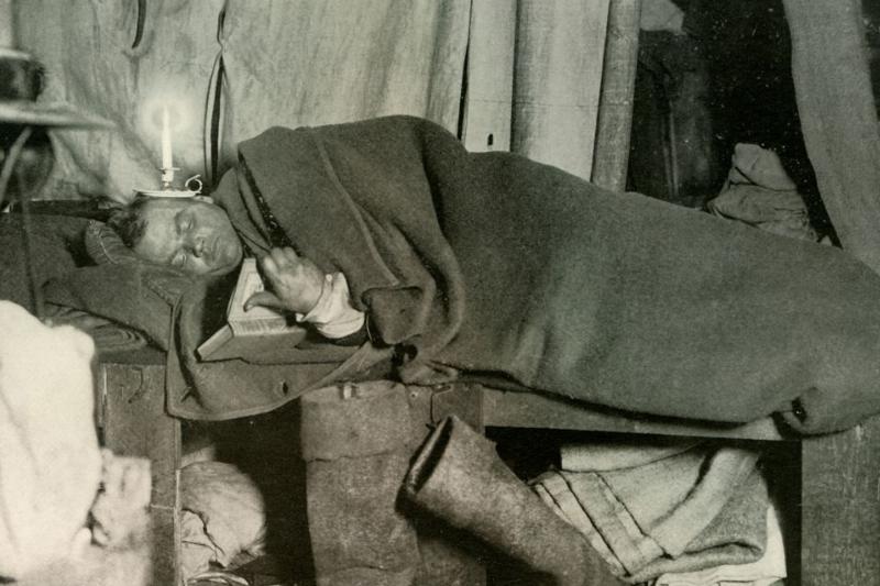 Man reading with candle on his head