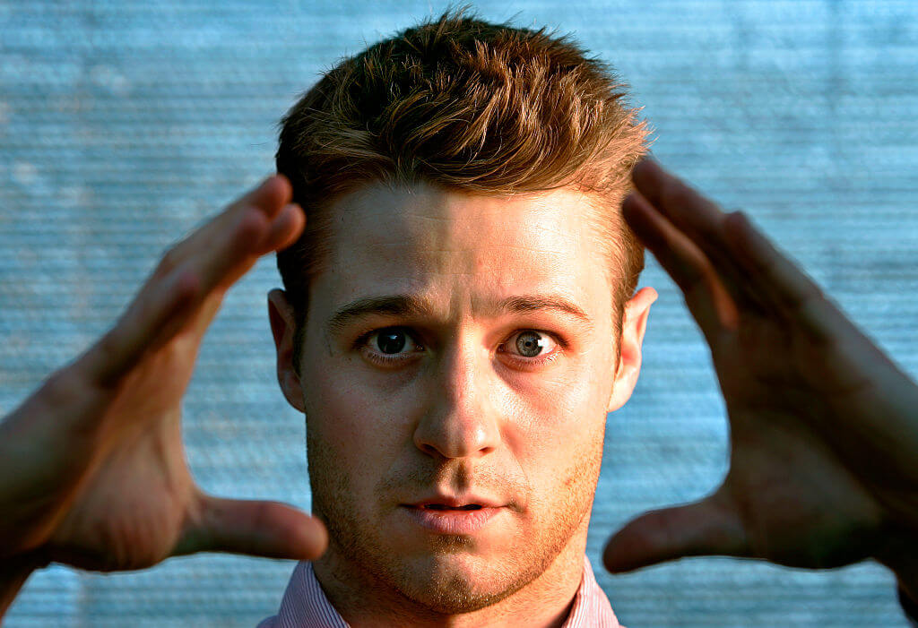 Ben McKenzie holds hands in front of face and poses for photo 