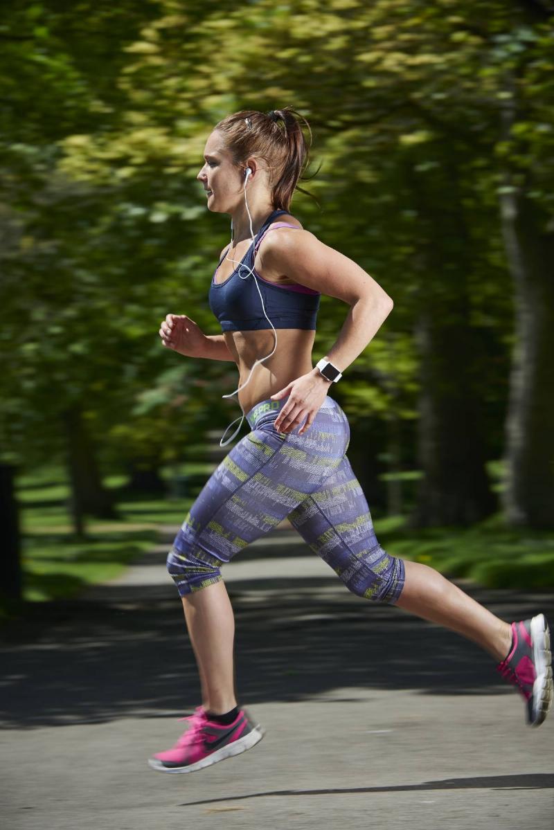 Portrait of a woman in sportswear running while modelling an Apple Watch Sport