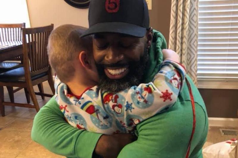 delvar hugging delvar in green shirt hugging kid in snowman pjs