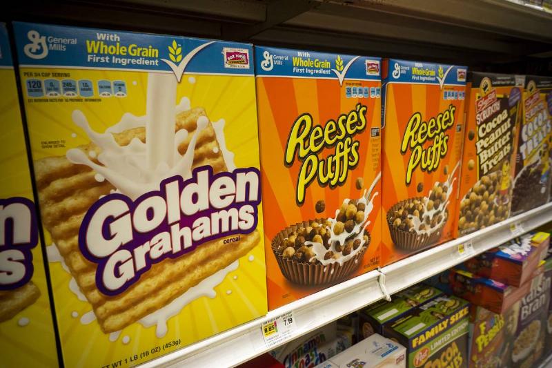 Boxes of General Mills breakfast cereals including Golden Grahams and Reese' Puffs displayed on supermarket shelves in New York 