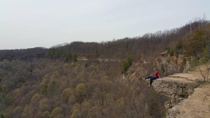 posing on cliff man in red shirt