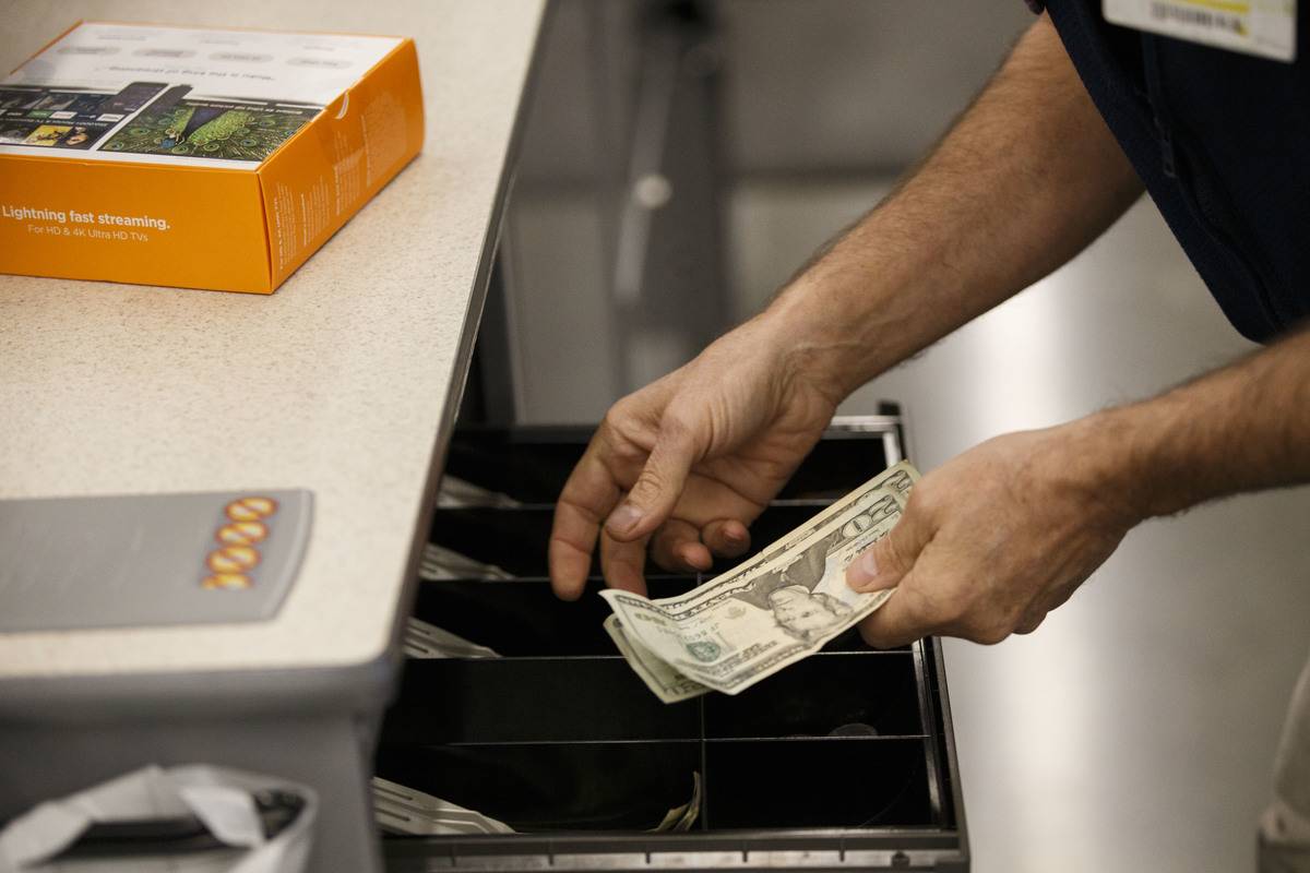Man putting cash into Walmart register