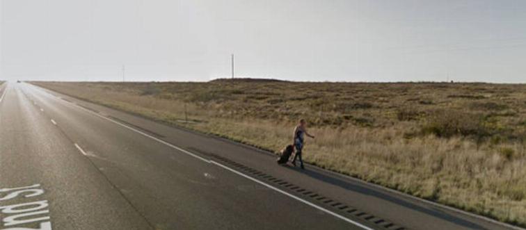 woman walking side of the highway