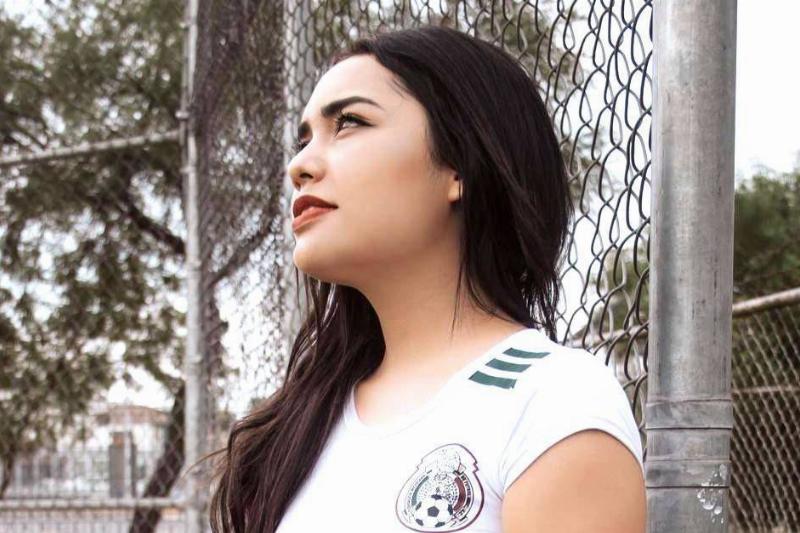 girl standing by a fence