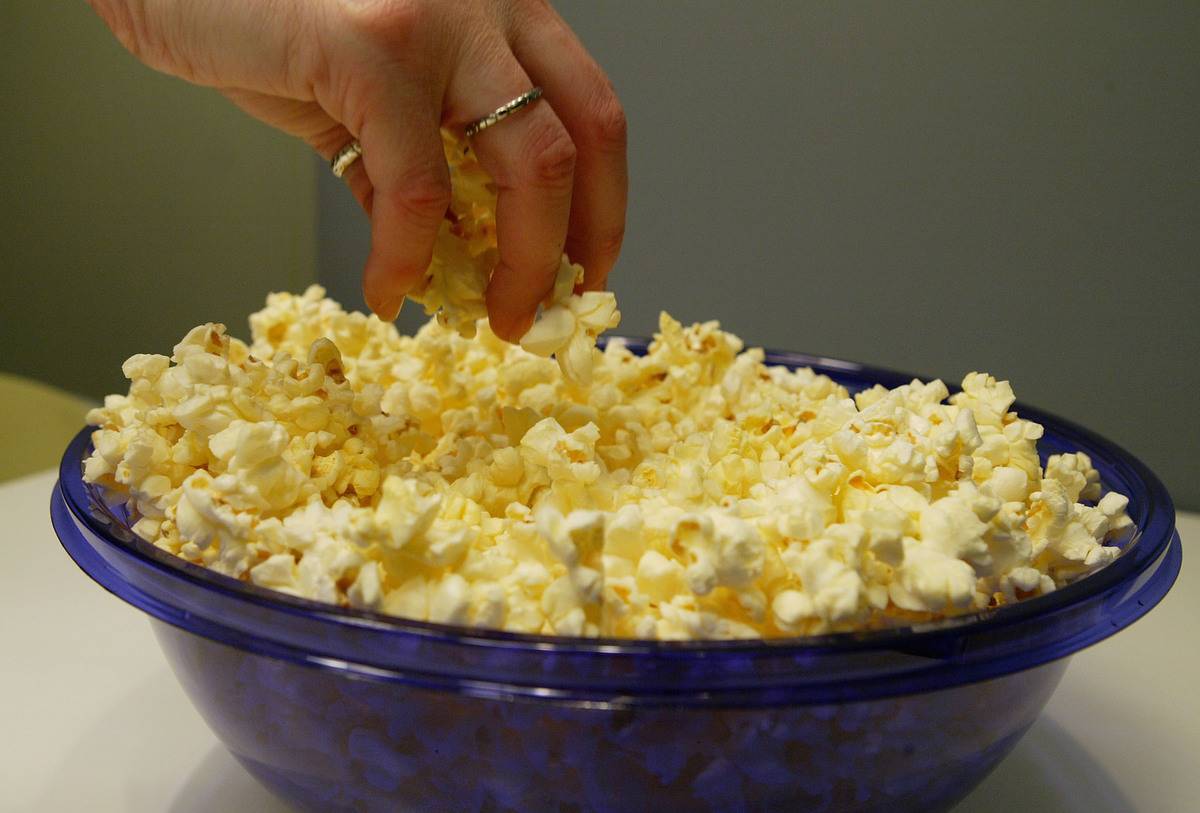 Popcorn A woman grabs freshly popped microwave popcorn from a bowl March 12, 2004 in New York City.