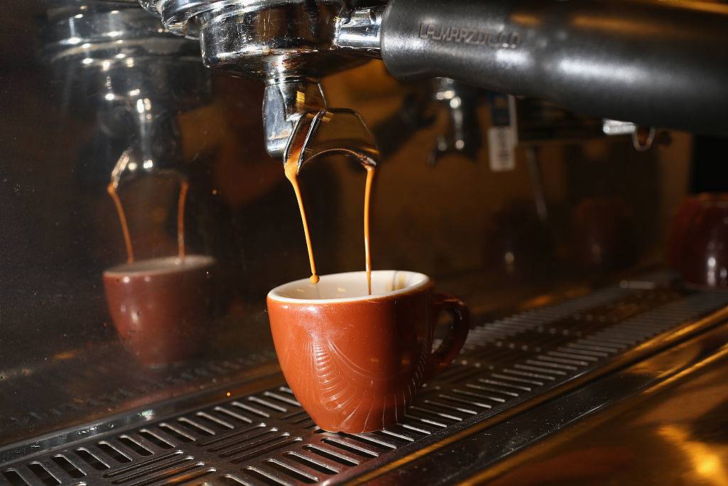 coffee is being poured into a mug