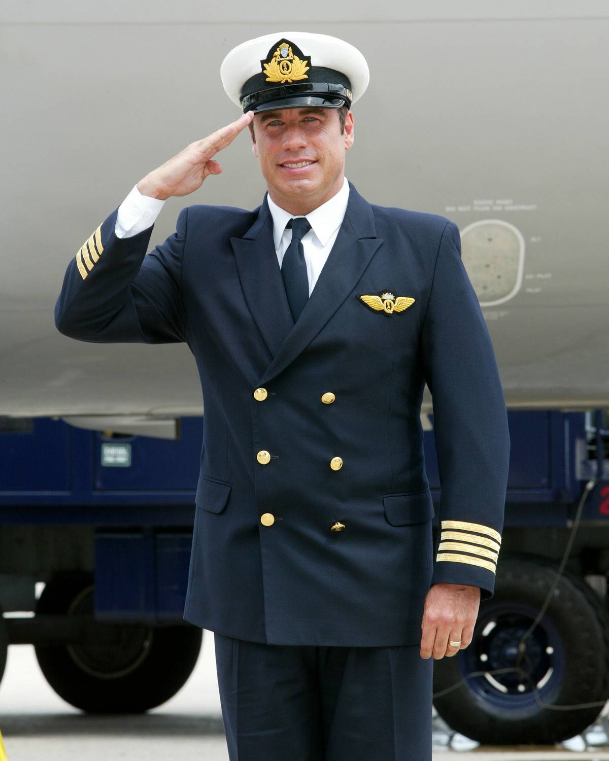 Actor John Travolta salues after arriving in his Quantas 707 