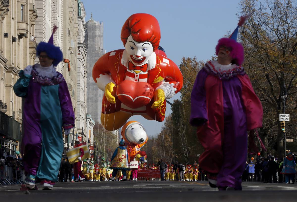 Clowns walk in front of the Ronald McDonald and Astronaut Snoopy  balloons on Central Park West during the Macy's Thanksgiving Day Parade 
on November 24, 2022, in New York City.