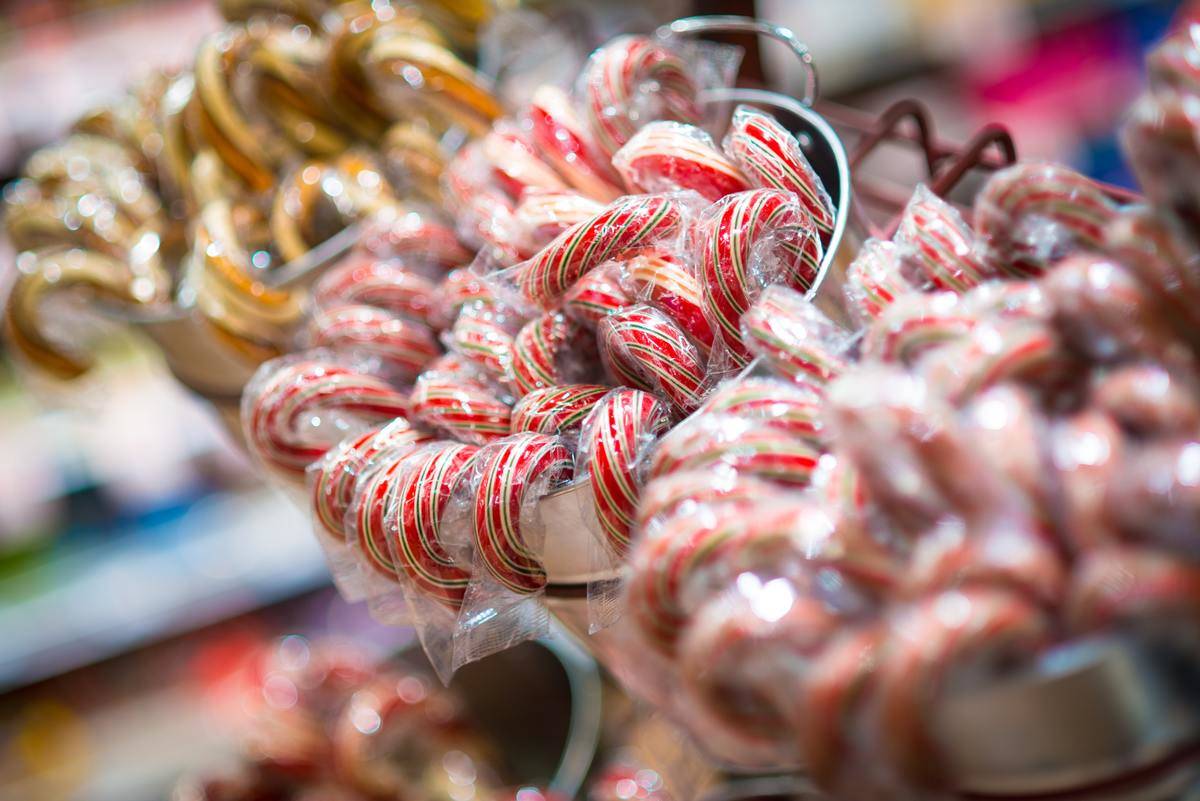 multi-colored candy canes sitting in small buckets at a store