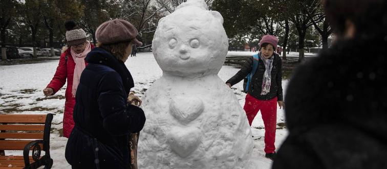 Residents make snowmen in Jiangtan park during snow in Jiangtan park on February 7, 2022 in Wuhan, Hubei, China.
