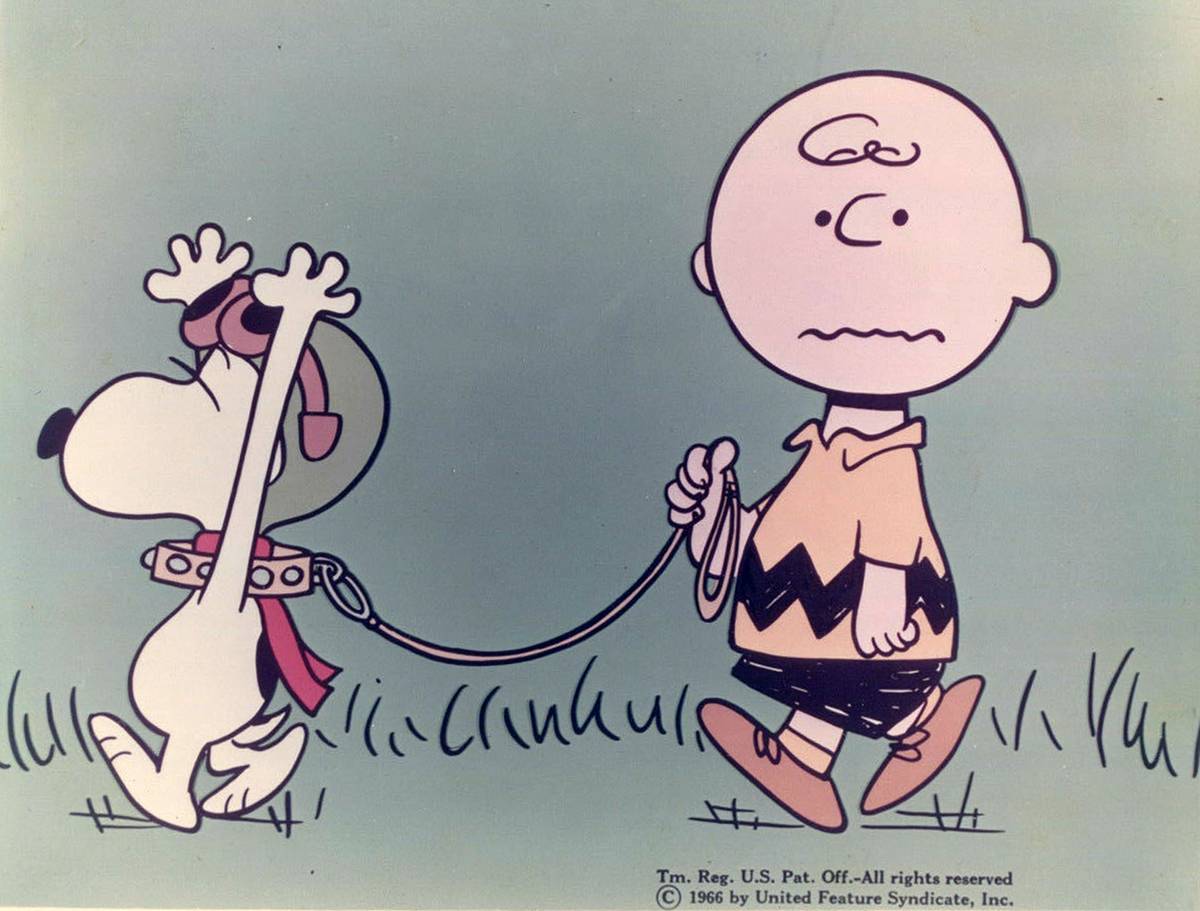Charlie Brown leading Snoopy on leash while he's wearing flying ace gear in He's Your Dog Charlie Brown