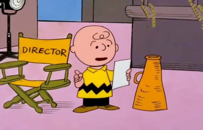 Charlie Brown reading next to director's chair in A Charlie Brown Christmas