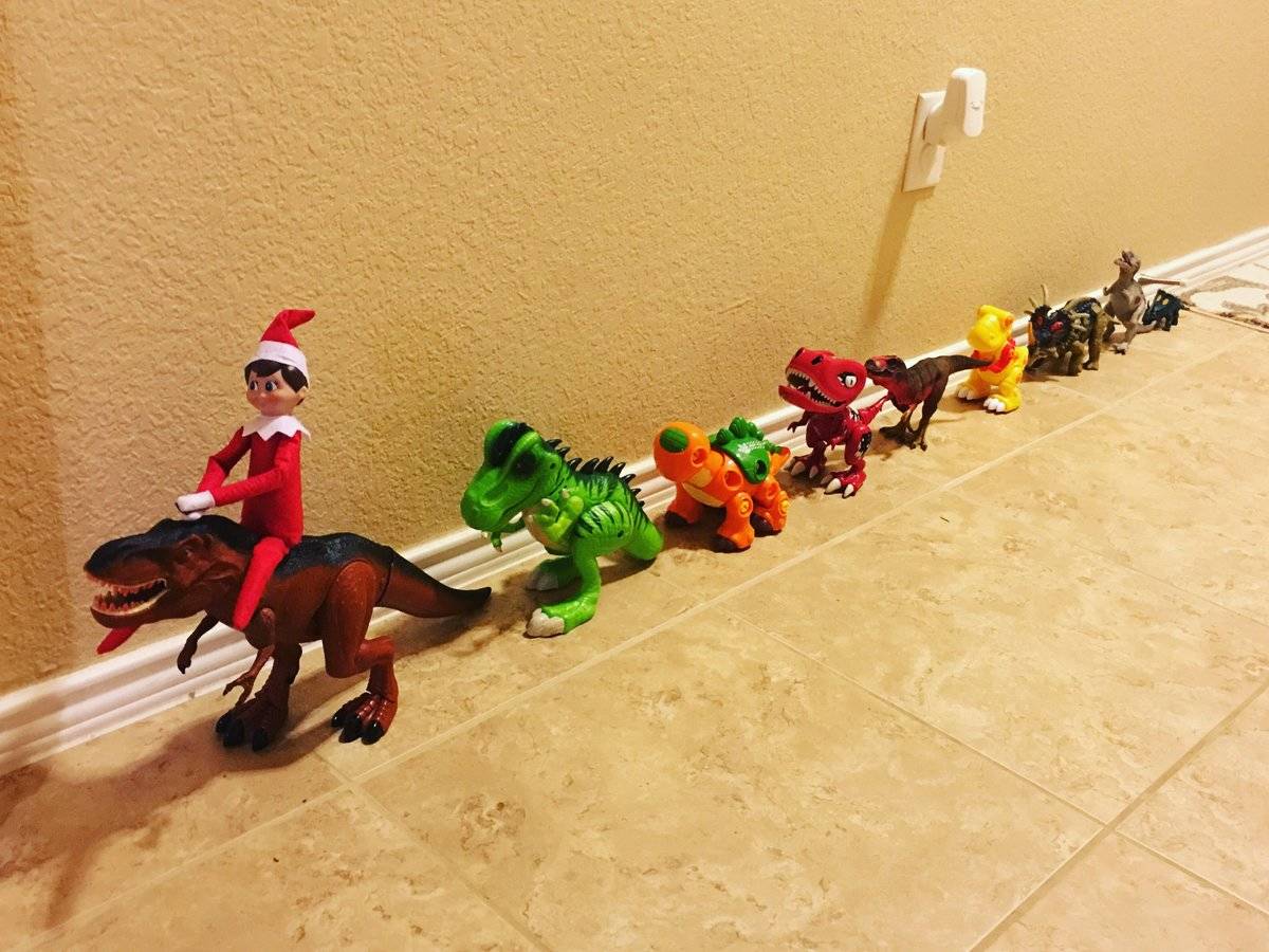 Elf on the shelf with friendly dinosaurs