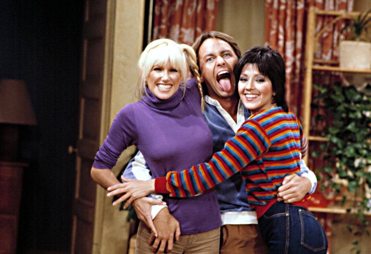 John Ritter sticking tongue out while embracing Suzanne Somers and Joyce DeWitt in Three's Company