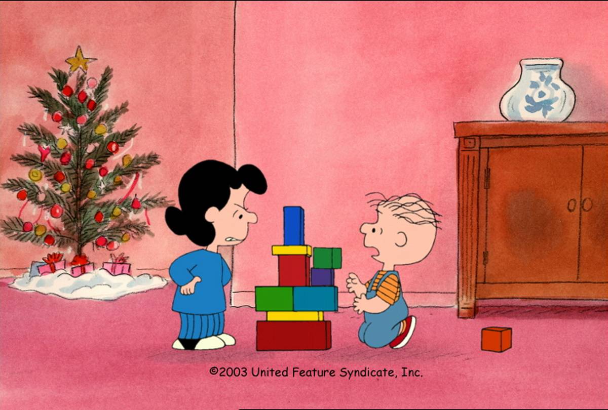 Lucy glaring at Linus next to building block tower in I Want A Dog For Christmas Charlie Brown