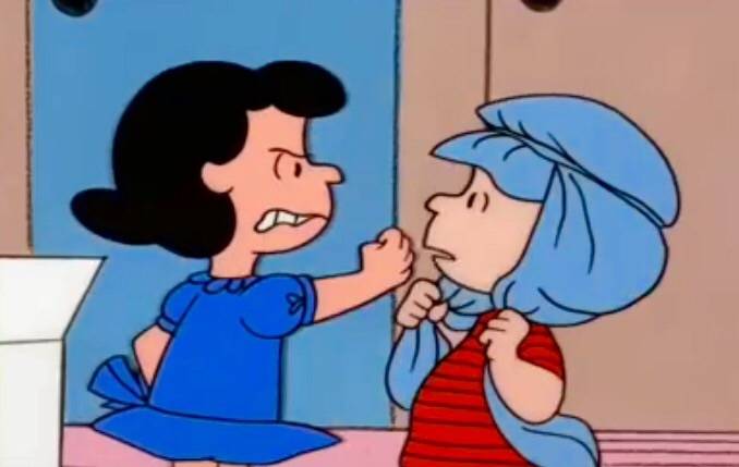 Lucy threatening Linus as he wears his blanket on his head in A Charlie Brown Christmas