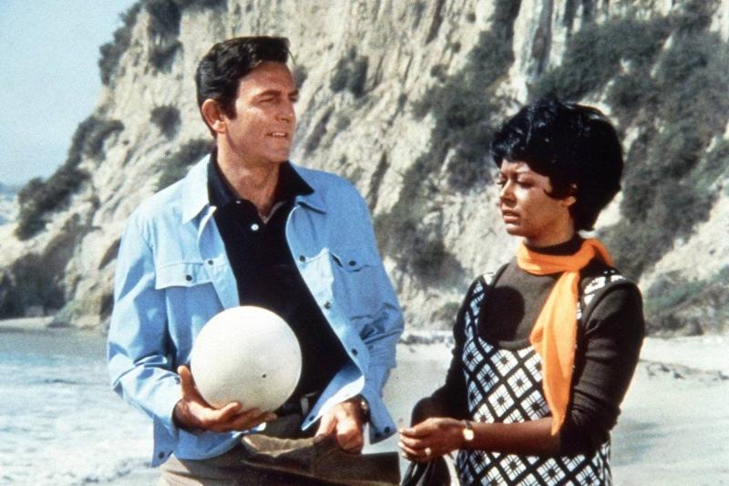 Mike Connors holding ball on beach next to Gail Fisher in Mannix