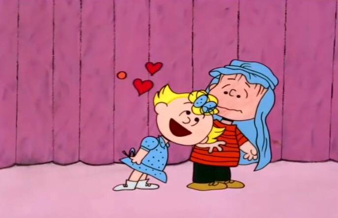 Sally showing affection to Linus with blanket on his head in A Charlie Brown Christmas