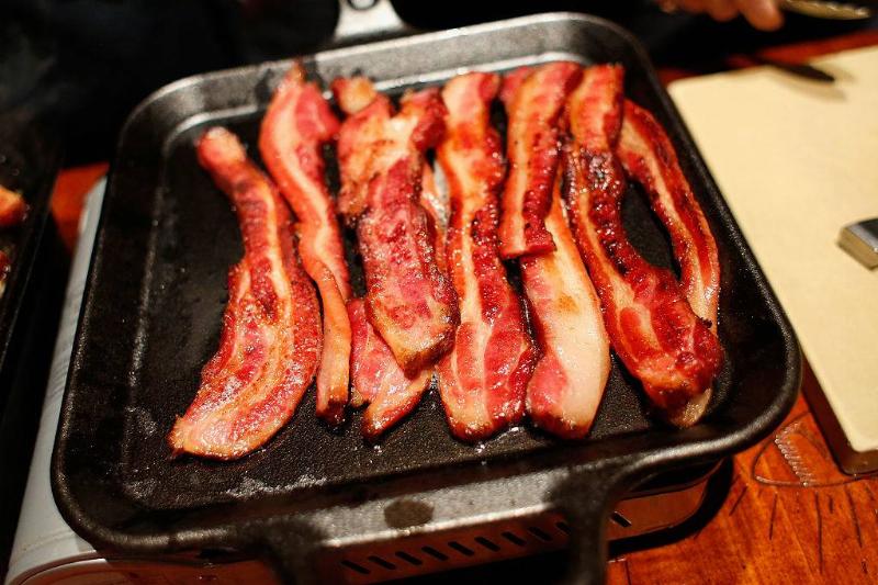 bacon 620178296 bacon grilling in a pan