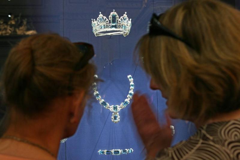 Two visitors look at an aquamarine and diamond tiara from Ga