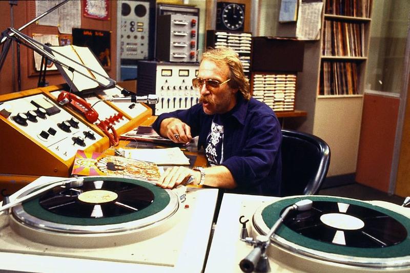 Howard Hesseman talking into radio microphone next to turntable as Dr. Johnny Fever in WKRP In Cincinnati