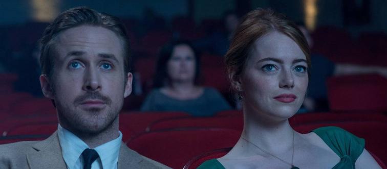 Emma Stone and Ryan Gosling as Mia Dolan and Sebastian Wilder sitting in movie theater in La La Land