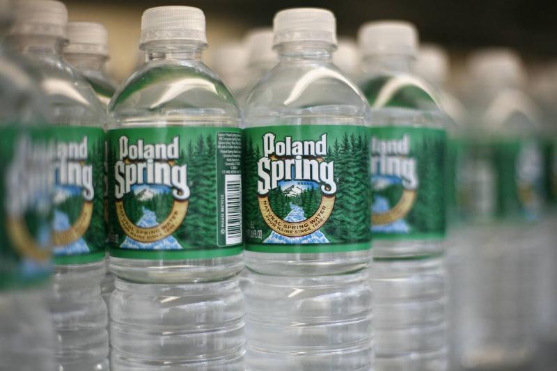 Bottles of Poland Spring water, are arranged on a shelf in N