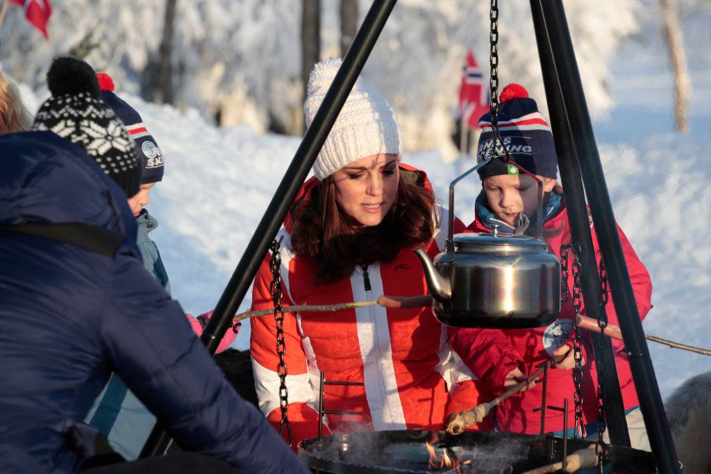 kate cooking at a campfire with children