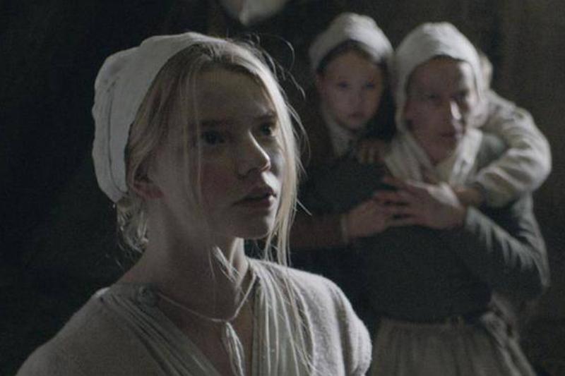 the-vvitch-a-new-england-folktale_FM7FHR Anya Taylor Joy standing in front of huddled women in The Witch