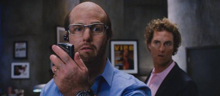 Tom Cruise talking into cell phone as Les Grossmann as Matthew McConaughey looks on as Rick Peck in Tropic Thunder