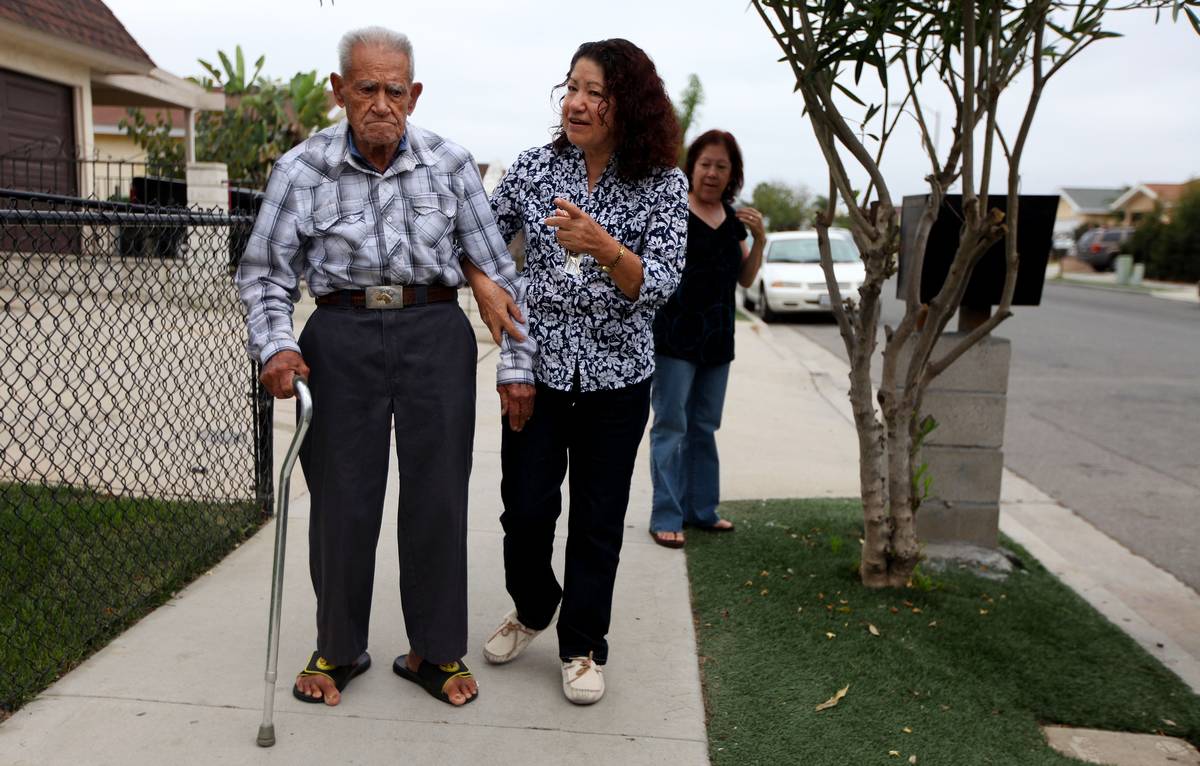 Trinidad de Leon takes a walk with his Daughter Maria de Leon with other daughter Ofelia de Leon, in back, on Thursday, October 14, 2010 in Oceanside, California. 