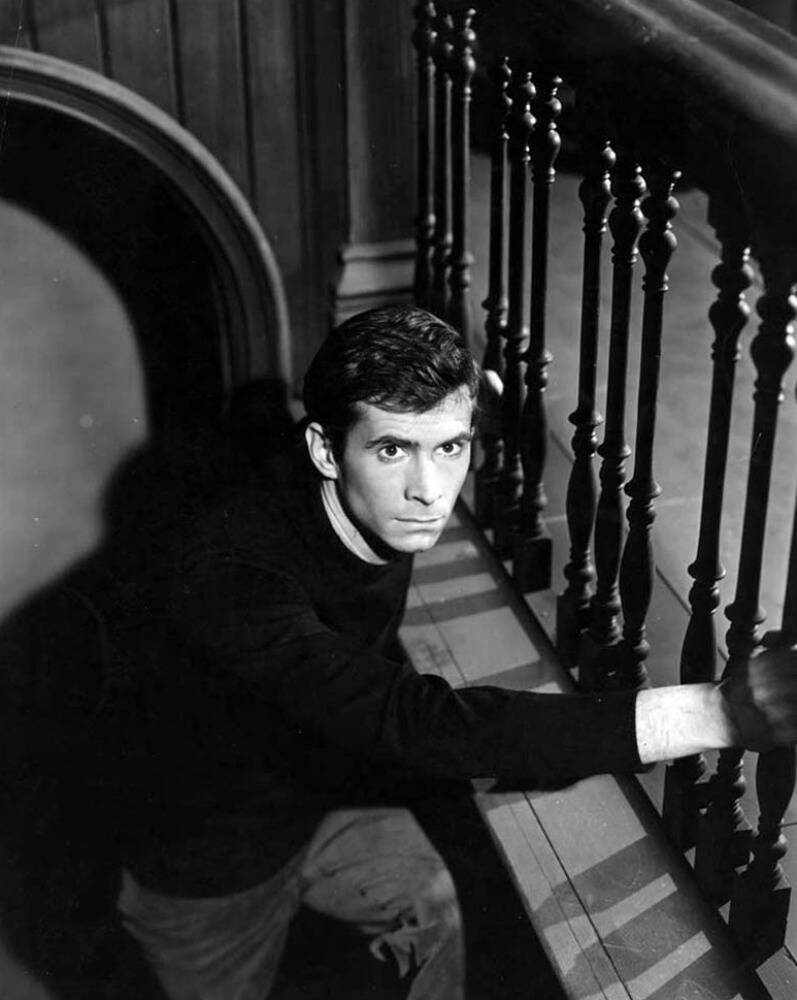 Anthony Perkins staring from staircase as norman Bates in Psycho
