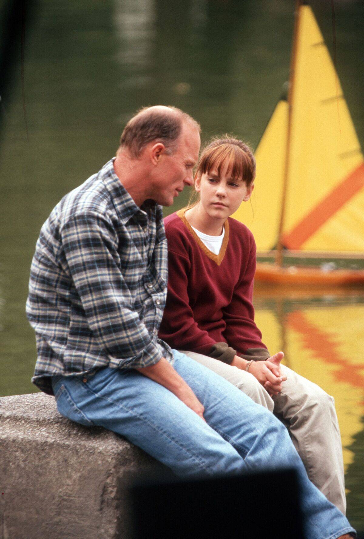 Ed Harris talking to Jena Malone next to model sailboat in Stepmom