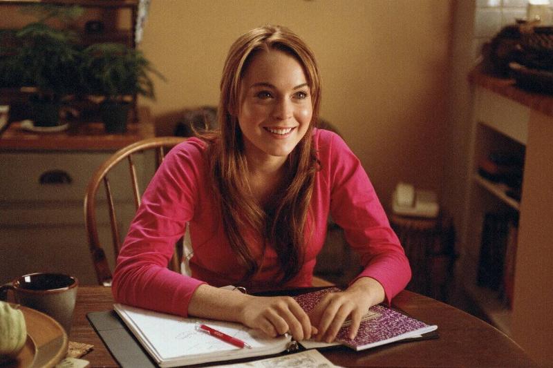 Lindsay Lohan smiling over school books as Cady Heron in Mean Girls