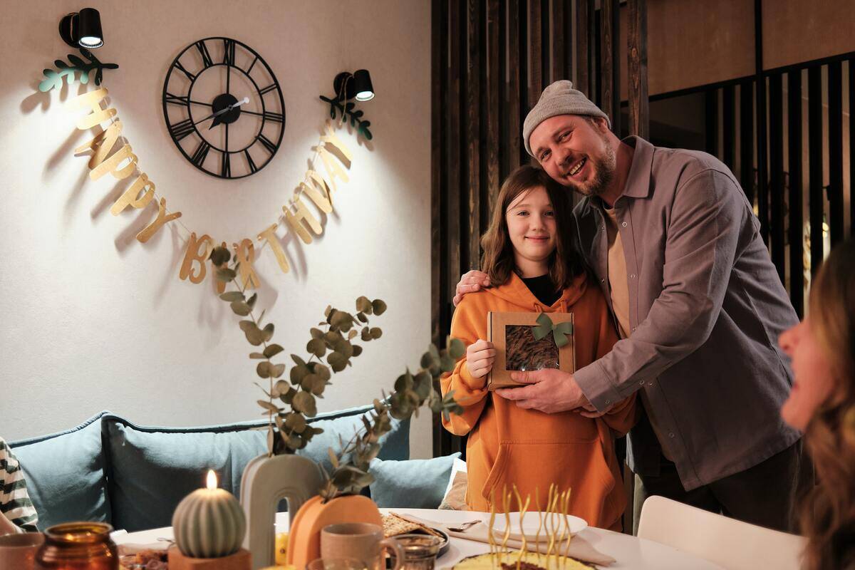 Man putting head close to daughter on her birthday