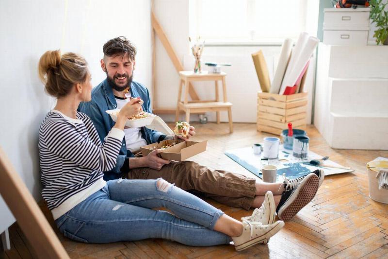 couple eating takeout on the floor after moving in together