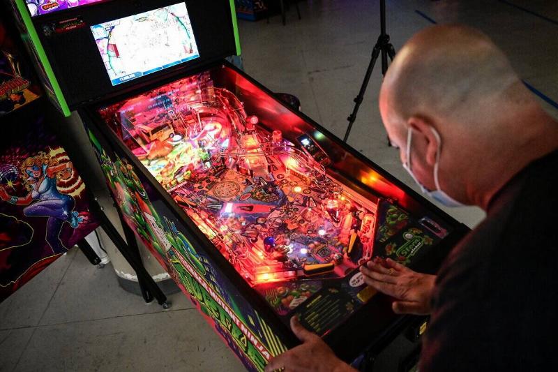 Man plays pinball at arcade at Long Island mall