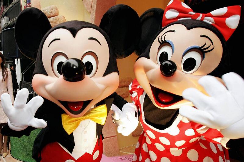 MIckey and Minnie Mouse wave to celebrat