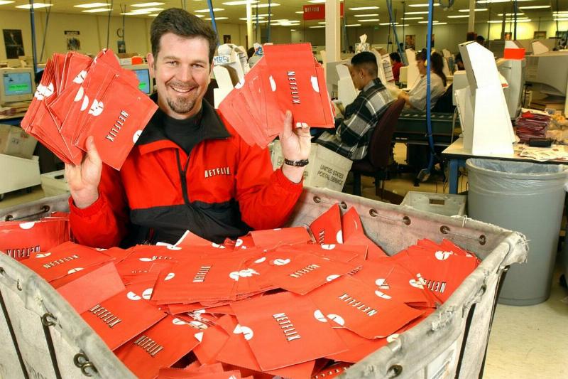 Chief Executive Officer Reed Hastings sits in a cart full of ready-to-be-shipped DVDs January 29, 2002 in San Jose, CA