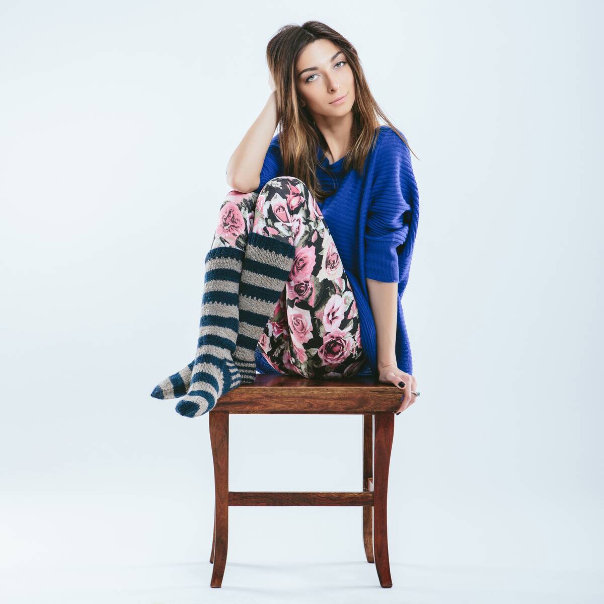 woman in striped socks perched on chair
