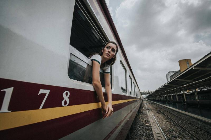 woman leaning out of train window and looking back