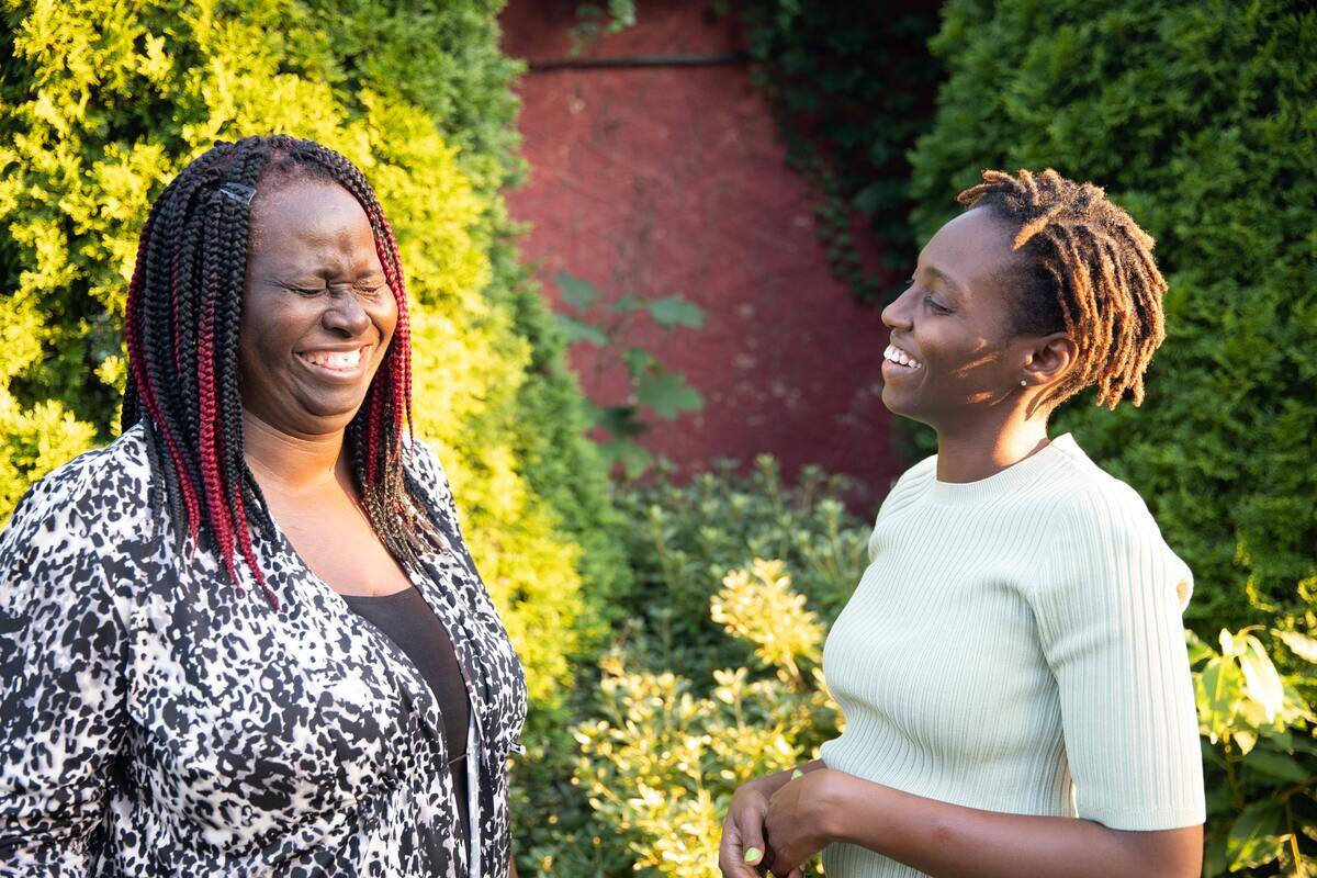 woman smiling while her sister hold in a laugh
