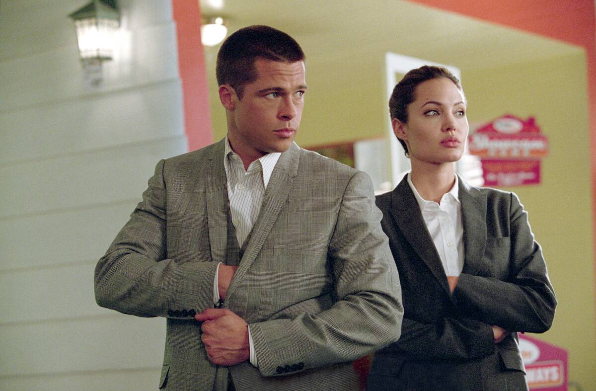 Brad Pitt and Angelina Jolie reach into their suits in Mr. & Mrs. Smith