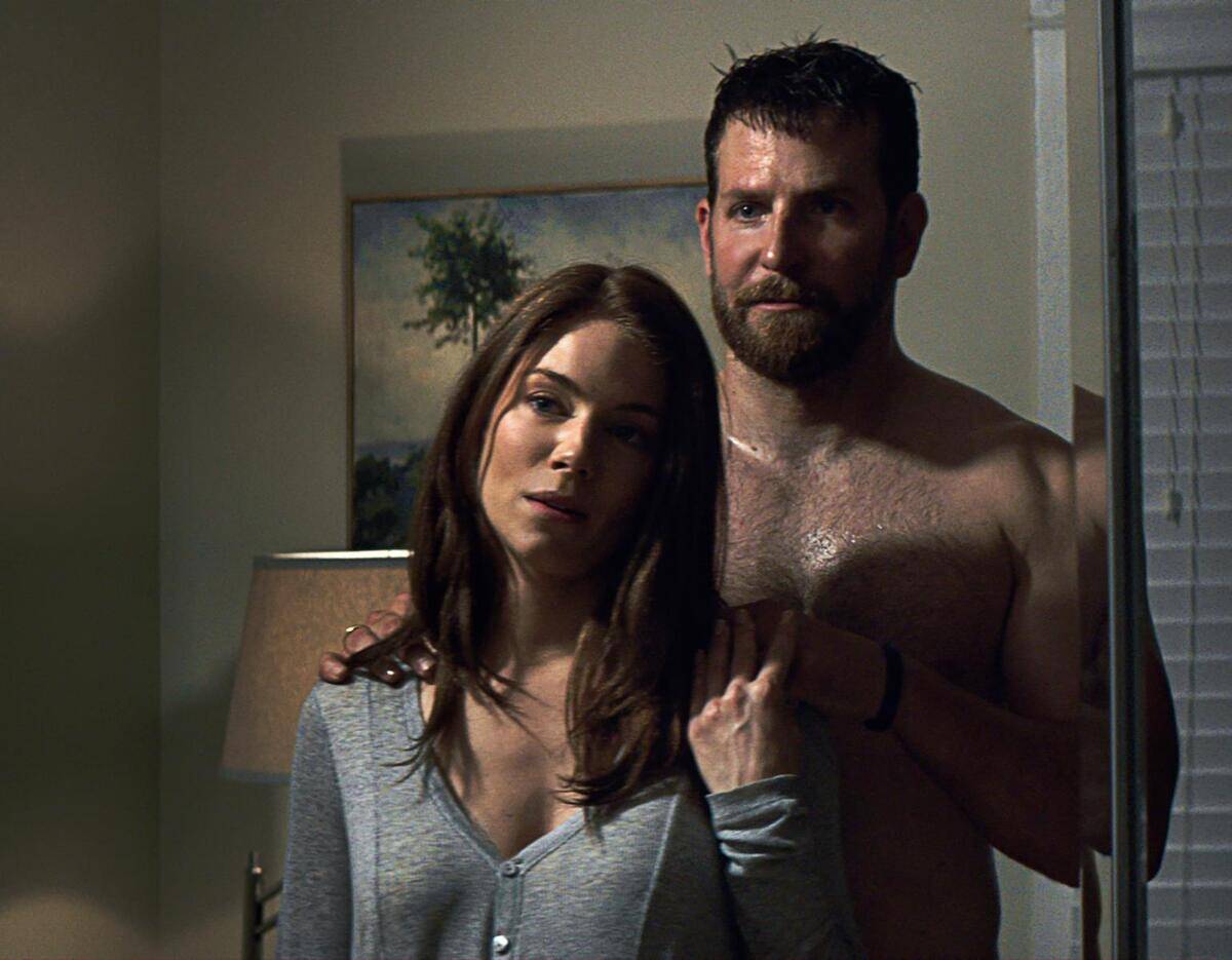 Bradley Cooper and Sienna Miller as Chris Kyle and Taya Renae Kyle in American Sniper